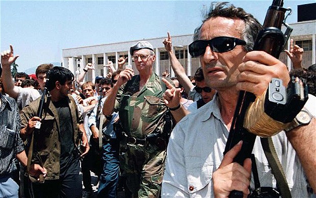 Zogu (centre)  flanked by bodyguards and supporters in Tirana's Central Square on his return in 1997